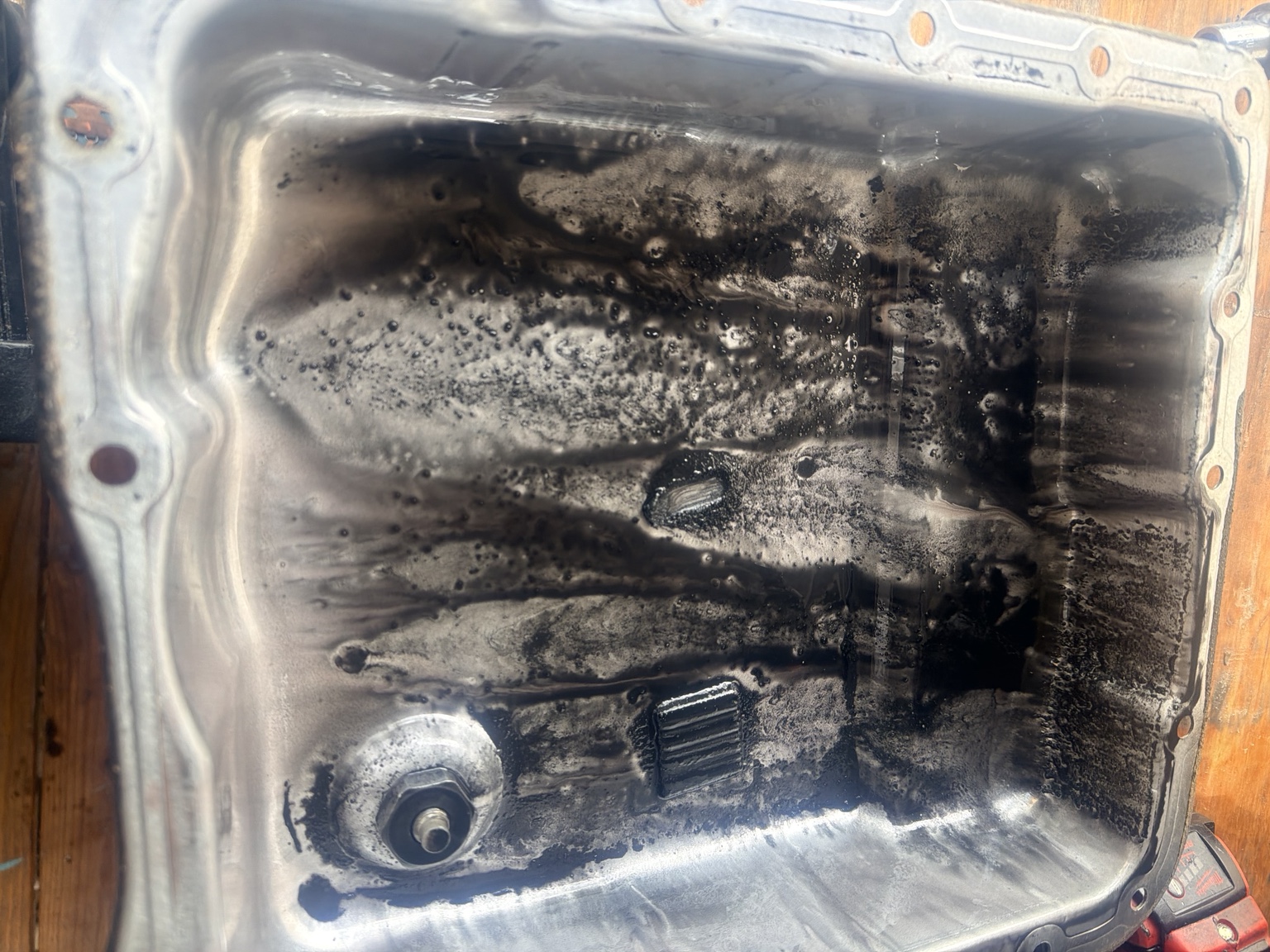 Dirty transmission pan showing fluid contamination and debris